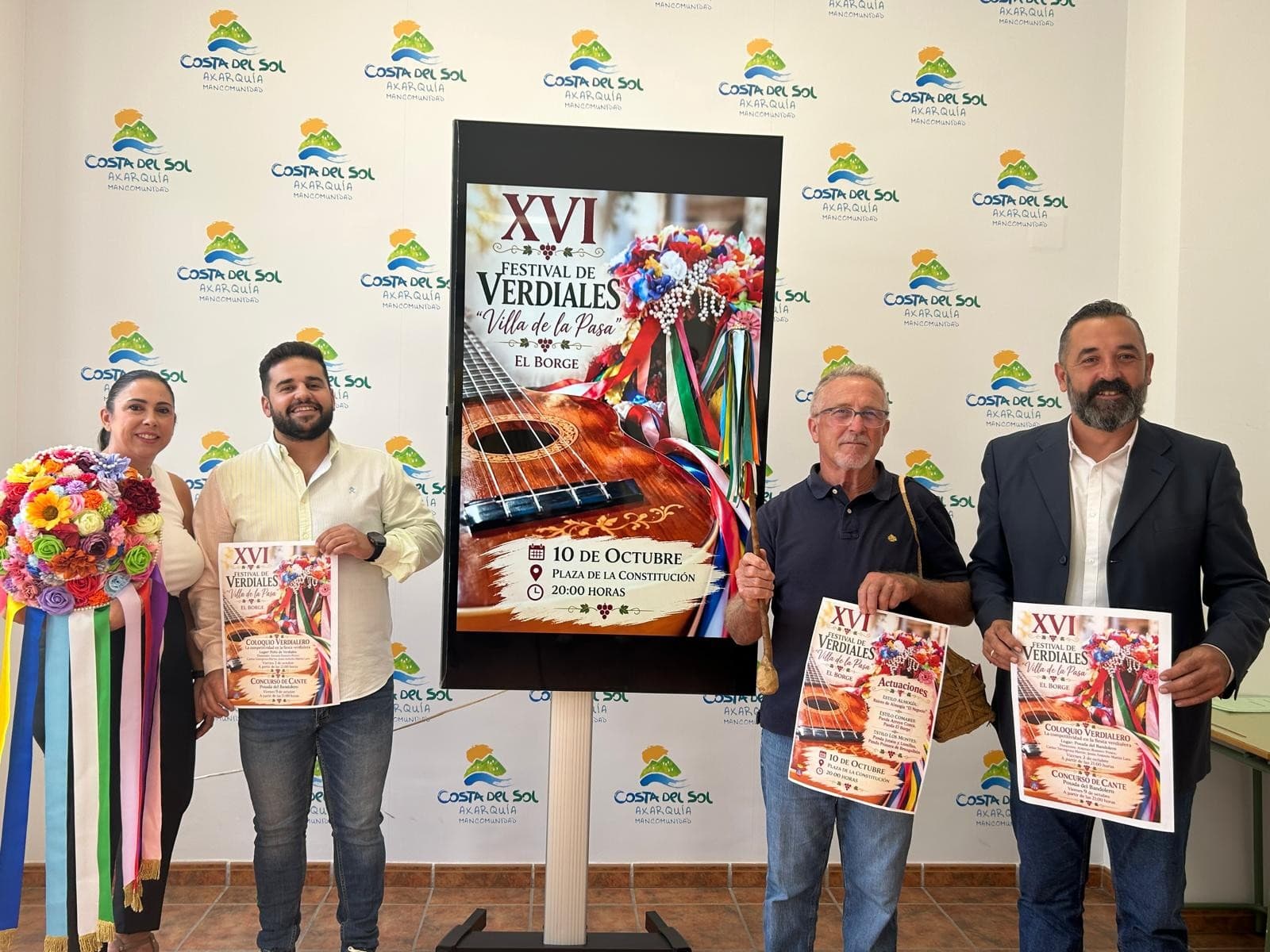 Presentación del XVI Festival de Verdiales «Villa de la Pasa» de El Borge en la Mancomunidad, con el cartel del festival y un sombrero de flores de verdiales