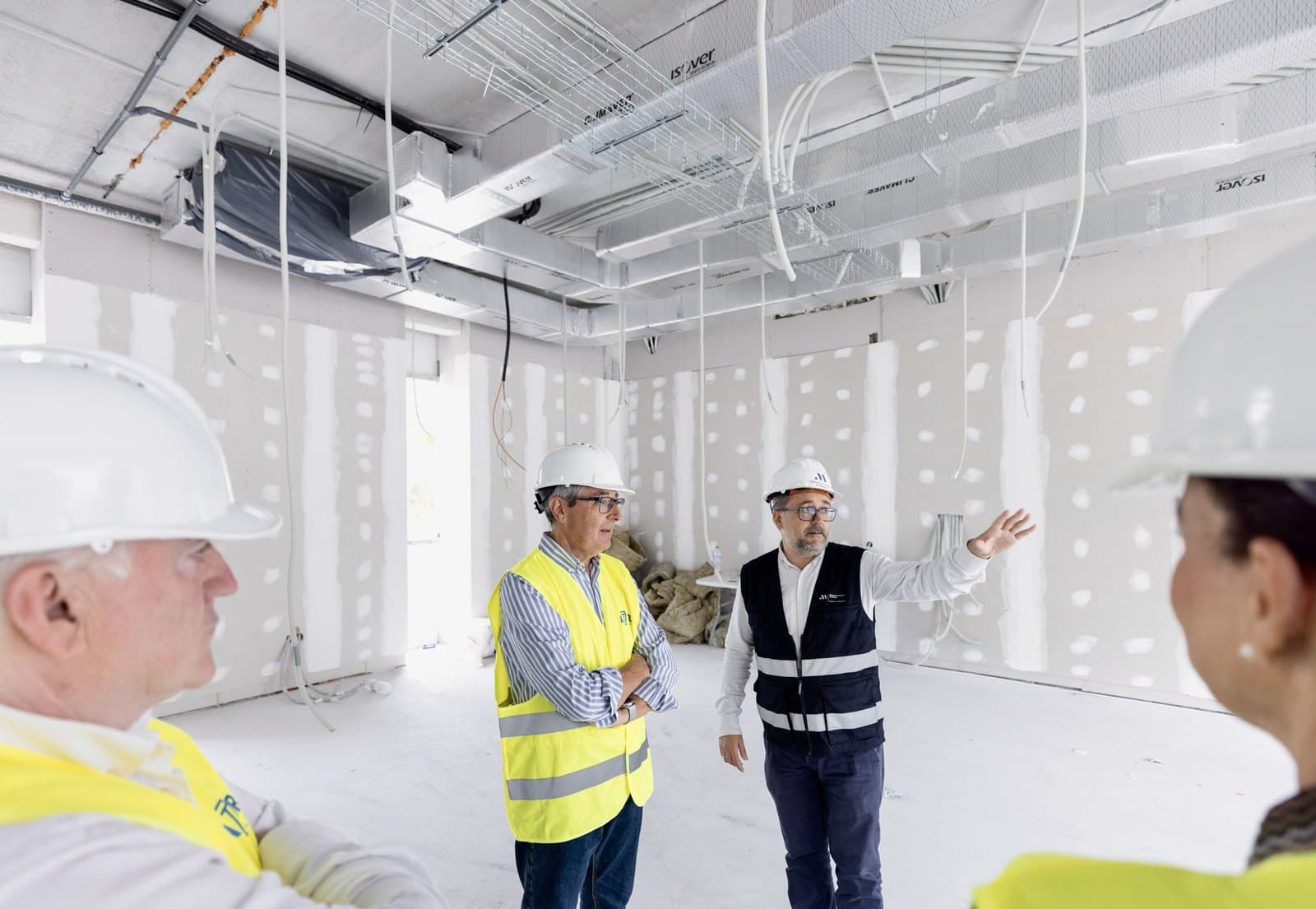 Responsables de la Diputación y del Consorcio de Bomberos, con casco blanco y chaleco, recorren el interior en obras del nuevo parque, con paredes de pladur e instalaciones en el techo