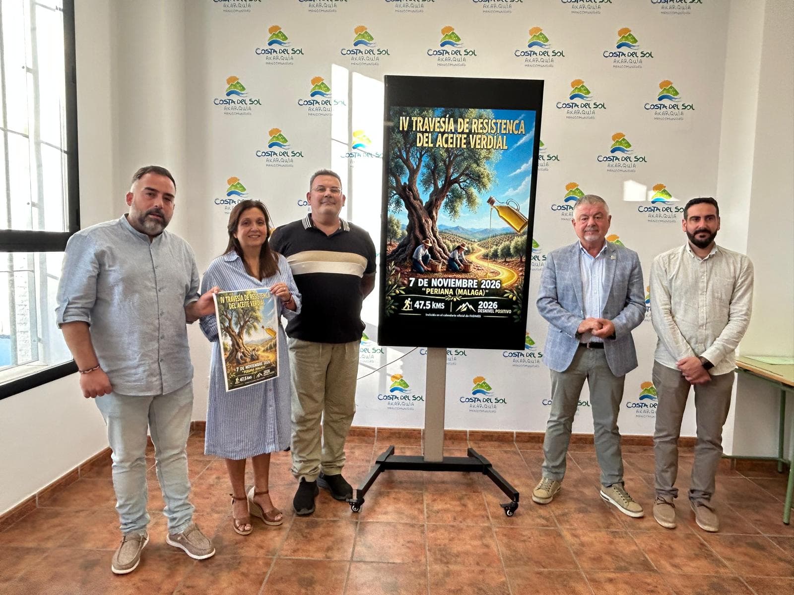 Representantes de la Mancomunidad, el Ayuntamiento de Periana y el C.D. Perianda junto al cartel de la IV Travesía de Resistencia del Aceite Verdial