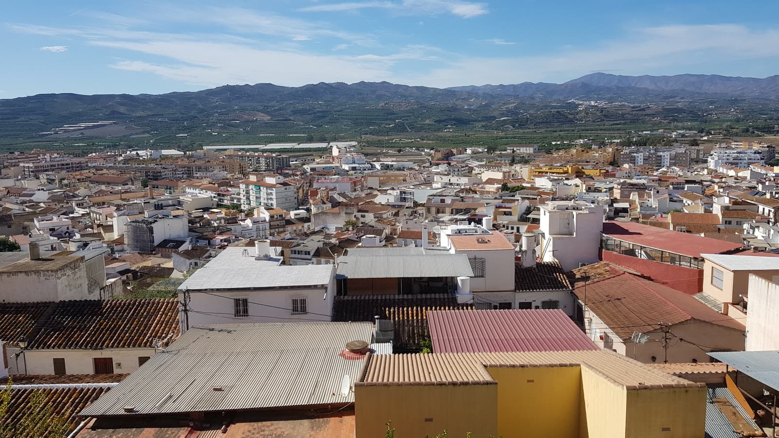 Tejados y azoteas del casco urbano de Vélez-Málaga, con la vega y los montes de la Axarquía al fondo.